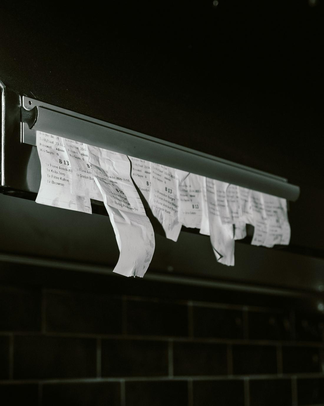 Order tickets hanging on a kitchen ticket rail